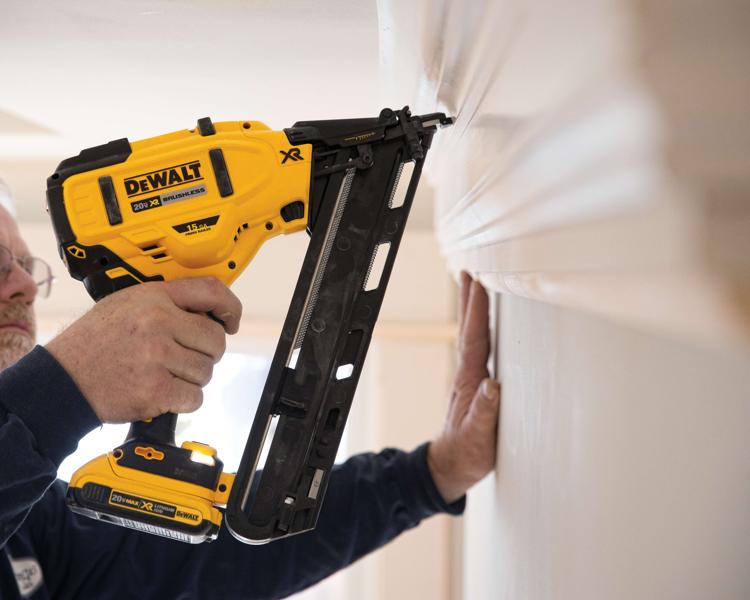 Eine Person verwendet einen DEWALT 20V XR bürstenlosen Akku-Nagler, um eine Leiste an einer Wand zu befestigen.